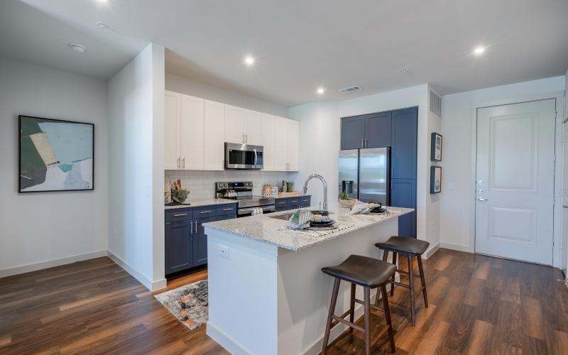 a kitchen with a bar stool and a white counter top