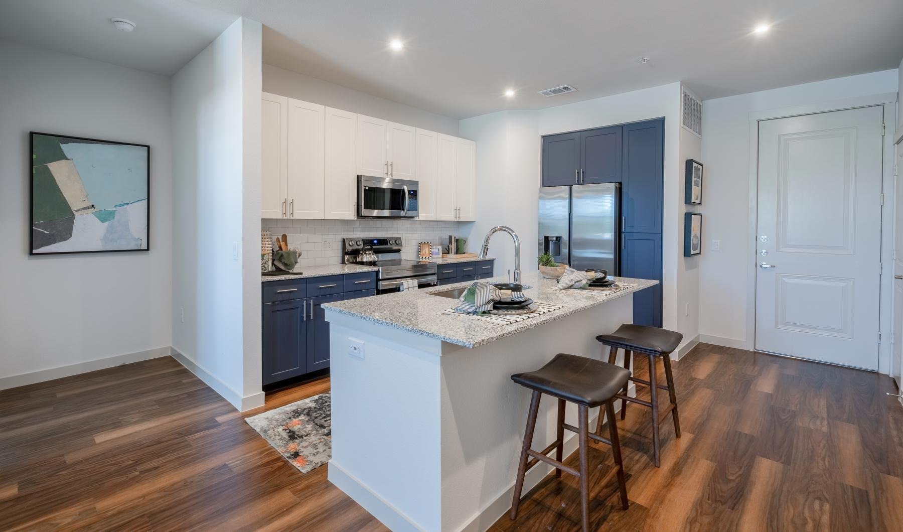 a kitchen with a bar stool and a white counter top